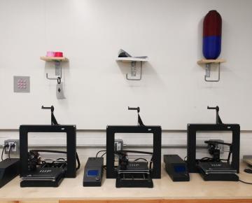 Three 3D Printers on a desk 