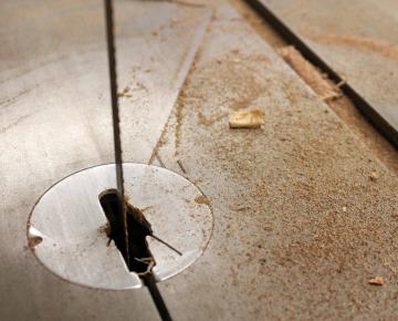 close up of a band saw blade with sawdust on the work table