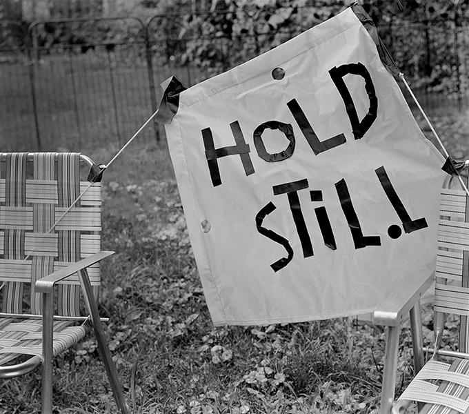 Lawn chair with banner that reads "Hold Still"